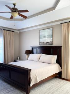 a bedroom with a bed with a ceiling fan at Modern Southern Comfort in Bowling Green