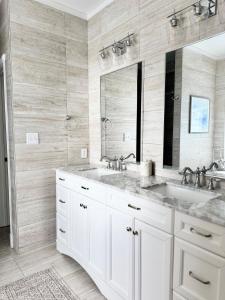 a white bathroom with a sink and a mirror at Modern Southern Comfort in Bowling Green