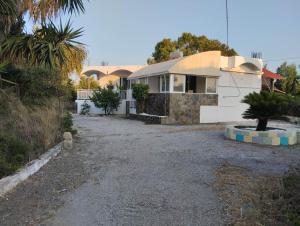 a house with a gravel driveway in front of it at Flora Beach House in Kremasti
