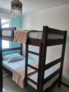 two bunk beds in a room with a chandelier at APARTAMENTO FERROCARRIL 201 in Ibagué