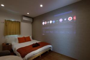 a room with a bed with a large screen on the wall at Life Town Shinkoiwa in Tokyo