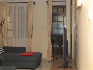 a living room with a couch and a flat screen tv at Beach View Bustani in Kalimoni