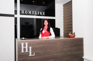 HomeLike Hotel في داوُجافبيلسْ: وجود امرأة جالسة في كونتر في غرفة الفندق