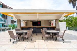 eine Terrasse mit Tischen und Stühlen sowie eine Küche in der Unterkunft Apt in Nuevo Vallarta, 5 min from beach in Nuevo Vallarta