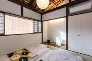 Postel nebo postele na pokoji v ubytování 京町家一棟貸しKyoto Machiya Stay En