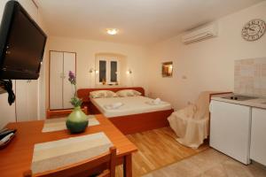 uma sala de estar com uma cama e uma cozinha em Apartments Caralipeo em Makarska