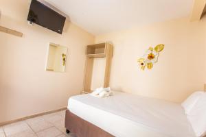 a bedroom with a bed and a tv on the wall at Psarotherma Rooms in Samothraki