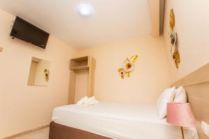 a room with two beds and a tv on the wall at Psarotherma Rooms in Samothraki +46 photos