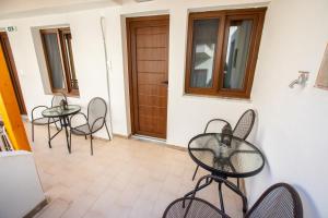 a room with two tables and chairs and a door at Psarotherma Rooms in Samothraki