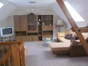 uma sala de estar com um sofá e uma televisão em Ferienwohnung am Storchennest em Schmogrow