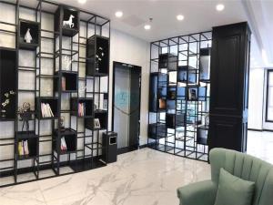 a room with a wall of shelves with books at Xana Lite Tianjin Beizhakou Town in Tianjin