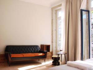 um sofá preto num quarto com uma janela em Historical Center House no Porto
