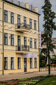 un grande edificio giallo con un cartello di fronte di HomeLike Hotel a Daugavpils