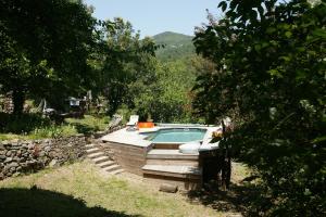 a swimming pool in a yard with a stone wall at le refuge des pots rouges in Cros