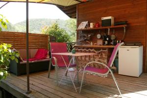 een terras met een tafel en stoelen bij le refuge des pots rouges in Cros