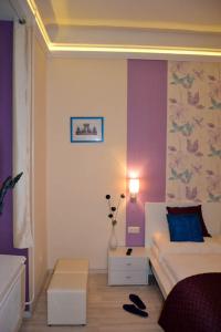 a bedroom with a bed and a purple wall at Magnolia Apartment in Budapest