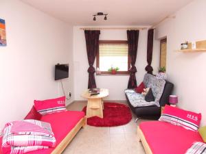 ein Wohnzimmer mit 2 Betten und einem Stuhl in der Unterkunft Apartment Ortler in Banská Štiavnica