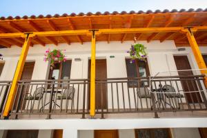 a balcony of a building with chairs and flowers at Psarotherma Rooms in Samothraki