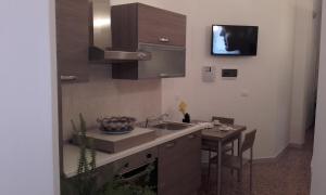 een keuken met een wastafel en een tafel met een tv bij B&B Mare Blu in Gallipoli