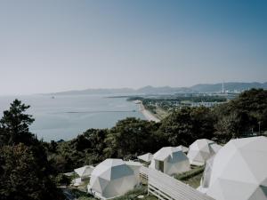 赤穗Dot Glamping 赤穂的山上一组俯瞰水面的白色帐篷