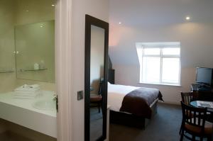 y baño con cama, lavabo y espejo. en Dinn Rí Hotel en Carlow