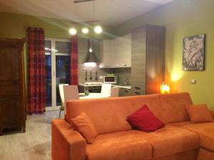 ジェノヴァにあるCasa Marinaのリビングルーム(オレンジ色のソファ付)、キッチンが備わります。