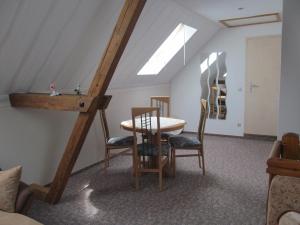 ein Zimmer mit einem Tisch und Stühlen im Dachgeschoss in der Unterkunft Ferienwohnung am Storchennest in Schmogrow