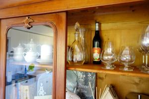 a shelf with wine bottles and glasses on it at Sparrow Sintra Nest in Sintra