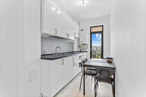 a kitchen with white cabinets and a table and chairs at Boemia Studio in Mamaia Nord