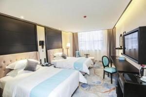 a hotel room with two beds and a flat screen tv at Xana Hotelle Hengayang Zhengshui Nan Road Dongfang Mingju in Hengyang
