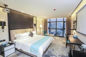 a bedroom with a large bed and a flat screen tv at Xana Hotelle Hengayang Zhengshui Nan Road Dongfang Mingju in Hengyang +199 photos