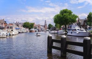 a couple of people are riding a boat down a canal at 3 Bedroom Cozy Home In Lemmer in Lemmer +21 photos