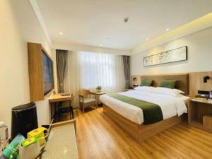 GuoyangにあるGreenTree Inn Express Bozhou Woyang County Huaizhong Avenue Zhonghai Internationalのベッドと机と机があるホテルの部屋
