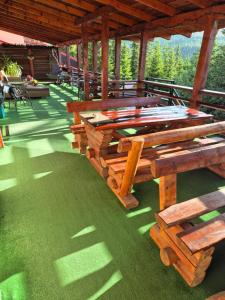 a group of wooden picnic tables on a patio at Vila Ozon in Ranca