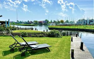 a bench and a picnic table on the grass by the water at Stunning Home In Lemmer With Wifi in Lemmer