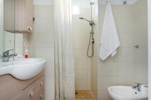 a white bathroom with a sink and a shower at Giosue' Apartment Near Bari - Happy Rentals in Adelfia