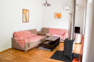 a living room with a couch and a wood stove at Ramybes Uostas in Švedriškė