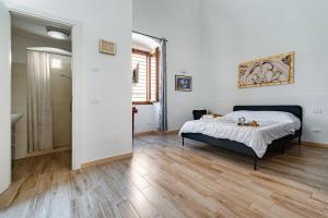 a bedroom with a bed and a wooden floor at Giosue' Apartment Near Bari - Happy Rentals in Adelfia