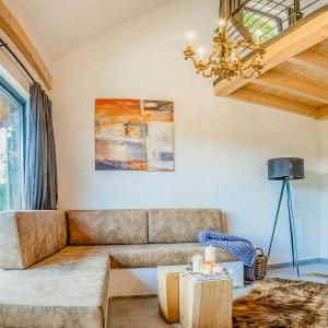 a living room with a couch and a chandelier at Modern Chalet With Sauna Near Thuringian Forest in Zella-Mehlis