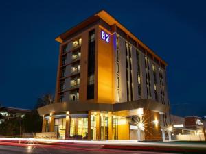 un bâtiment d'hôtel avec une horloge dessus la nuit dans l'établissement B2 Surat Thani Premier Hotel, à Surat Thani