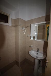 W łazience znajduje się umywalka i lustro. w obiekcie Belvedere Paleo w mieście Paleokastritsa