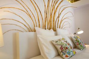 a bed with pillows and a wall with a painting at Sparrow Sintra Nest in Sintra
