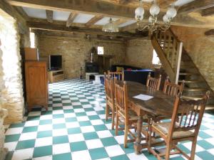 uma sala de jantar com uma mesa e um piso em xadrez em La Prairie em Siorac-en-Périgord