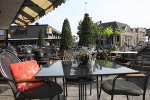 - un ensemble de tables et de chaises sur une terrasse dans l'établissement Hotel Restaurant De Zwaan, à Raalte