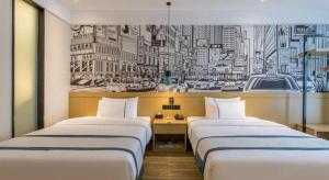 two beds in a room with a mural of a city at City Comfort Inn Dalian Changxin Dao Santang Commercial Street in Wafangdian