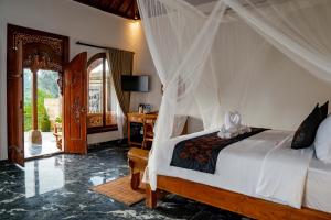 a bedroom with a bed with a canopy at Grand Campuhan in Tegalalang