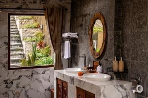 a bathroom with two sinks and a mirror at Grand Campuhan in Tegalalang +129 photos