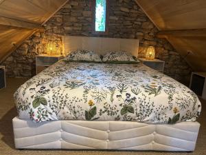 a bedroom with a large bed in a stone wall at La Cazelle, charme sport et détente in Saint-Chels
