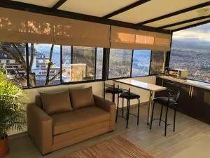 a living room with a couch and a table with chairs at Azotea Suites & Apartments in Cuenca