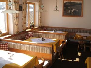ein Esszimmer mit Tischen, Stühlen und einem Tisch in der Unterkunft Grieswirt in Sankt Johann in Tirol